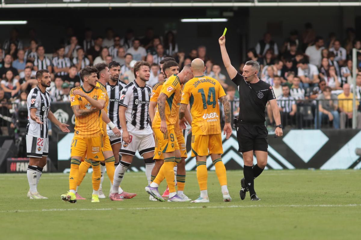 El colegiado del Castellón-Albacete, Alonso de Ena, muestra una amarilla.