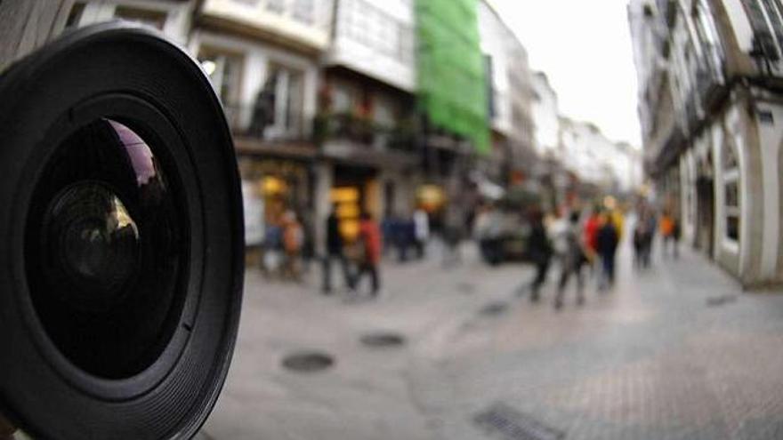 Un objetivo de una cámara vigila una céntrica calle coruñesa. / fran martínez