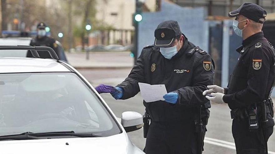 Dos policías nacionales comprueban la documentación de una conductora en control el viernes.