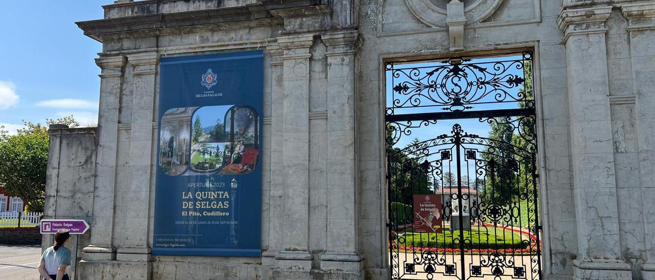 Una vecina repara nel cartel qu'anuncia l'empiece de les visites na puerta de la Quinta de los Selgas.