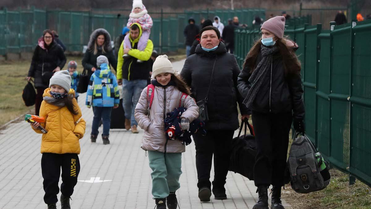 Grupos de gente cruzando la frontera entre Ucrania y Polonia, en Medyka