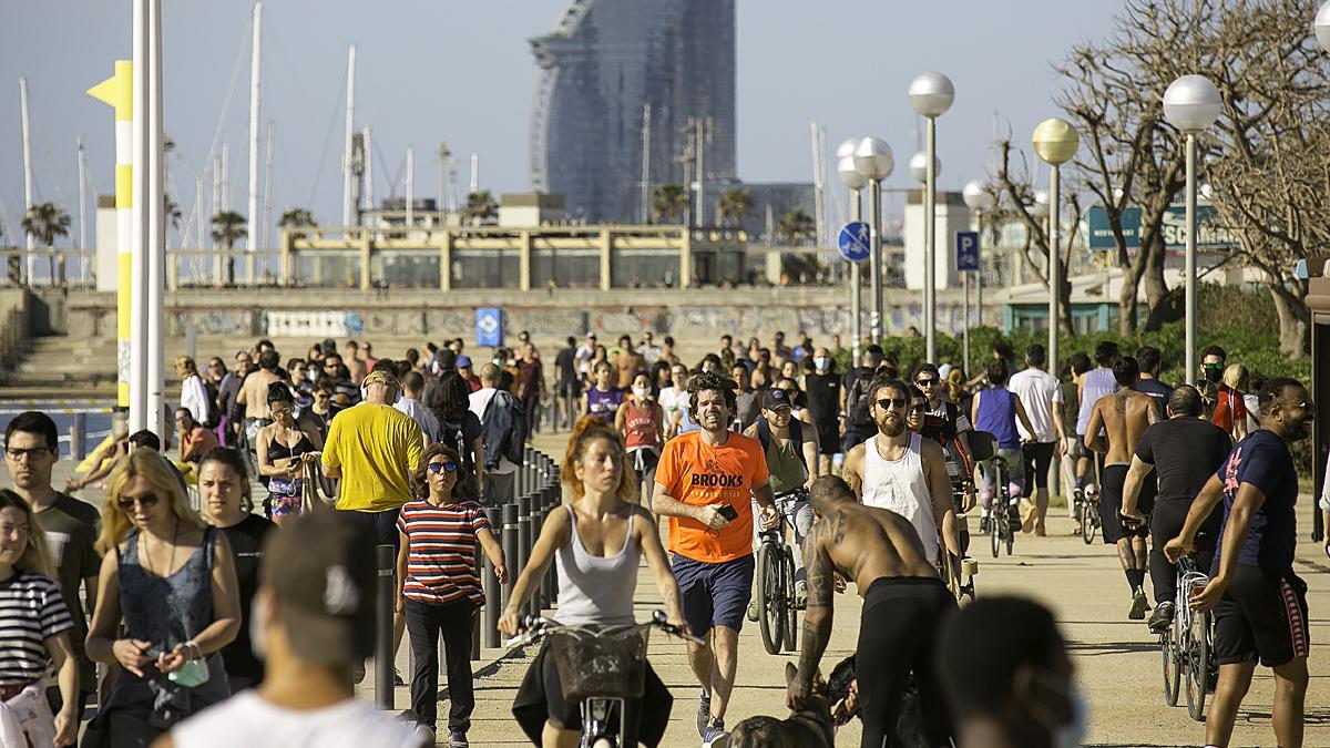 Decenas de personas pasean y hacen deporte por el Paseo Marítimo de Barcelona en la noche de este domingo.