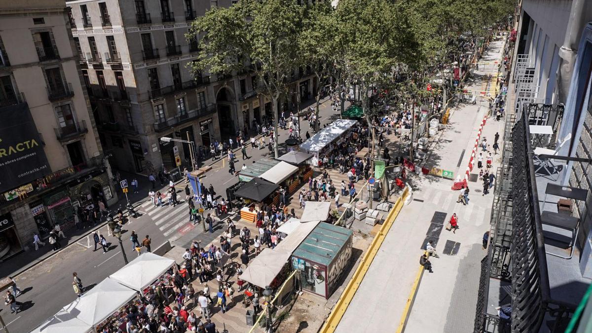 La Rambla con paradas de libros y rosas por Sant Jordi y las obras en el lado del Gòtic.