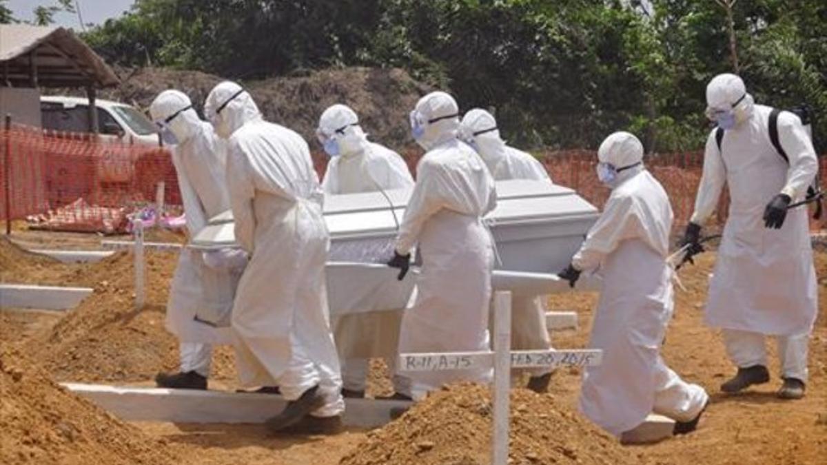 Sanitarios trasladan el cadáver de una víctima de ébola, el pasado marzo, en Monrovia (Liberia).