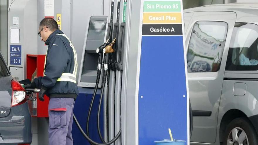 Un trabajador de una estación de servicio suministra gasolina a un coche.