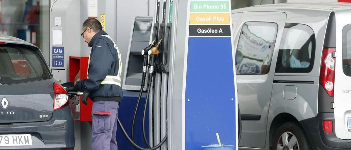 Un trabajador de una estación de servicio suministra gasolina a un coche.