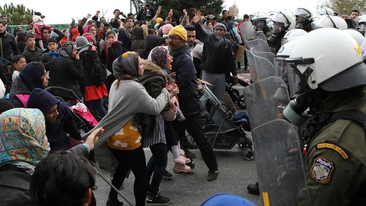 Un grupo de refugiados del campo de Moria se enfrenta a la Policía griega, este lunes.