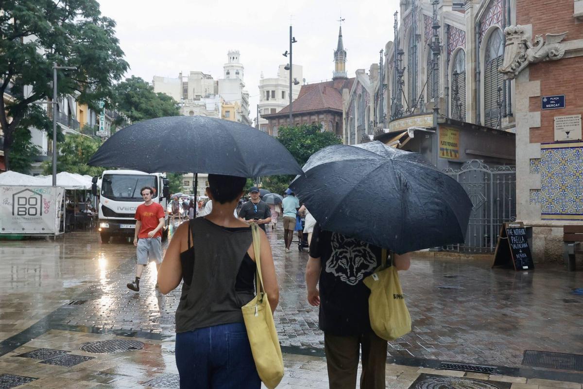 Personas con paraguas en València.