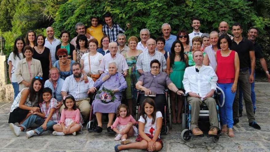Rosa Álvarez, sentada con un ramo de flores, en la celebración de su 105 cumpleaños con su familia.