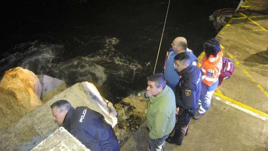 Agentes de la Policía Nacional, sanitarios y un pescador, ayer, en O Portiño. // Víctor Echave