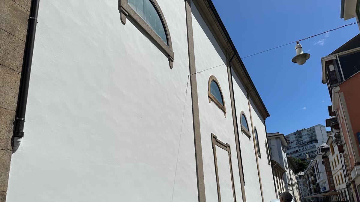 Un viandante observa la fachada de la iglesia de Luarca.