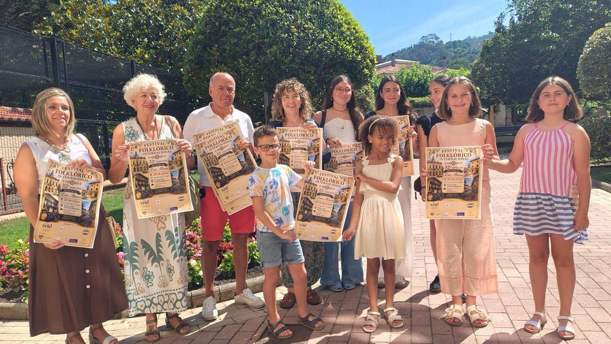 Integrantes del Grupo Folclórico Villaviciosa Aires de Asturias, entre ellos Elena Alonso y Carlos Vigil, acompañados por las concejalas Rocío Vega y Laura Montequín, con los carteles promocionales del evento.