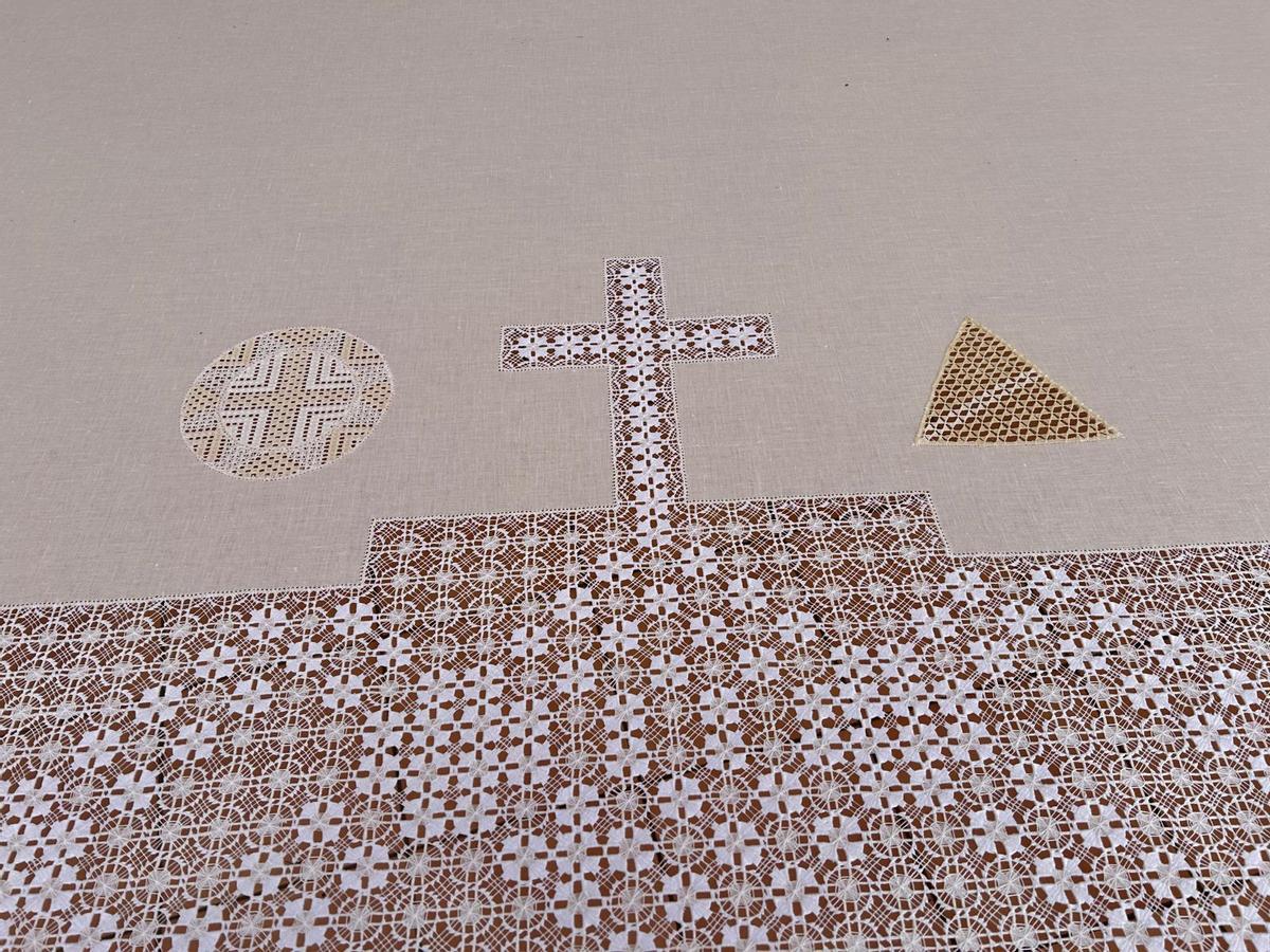 El mantel de altar con la cruz en el centro y las pintaderas canarias a los lados.