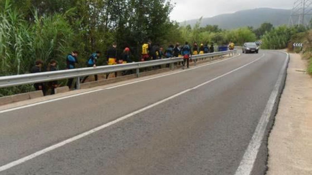 Excursionistas circulan por el margen de la CV-580, en un tramo próximo a un paraje de Anna.