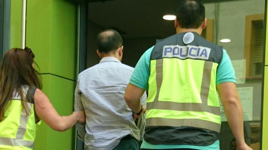 La Policía Nacional con el detenido en la puerta principal de la Comisaría de Cartagena