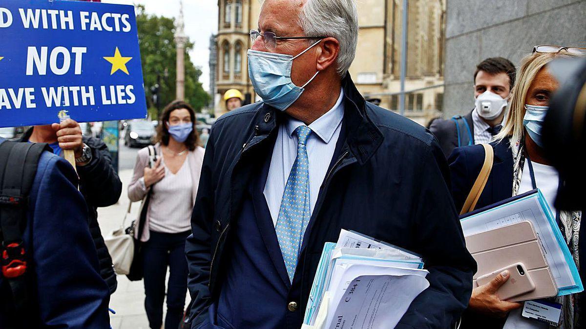 Barnier, en una calle de Londres, junto a una pancarta contraria al &quot;Brexit&quot;.