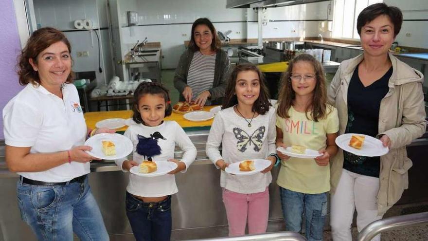 Un grupo de niños participantes en el encuentro recogen el postre. // Muñiz