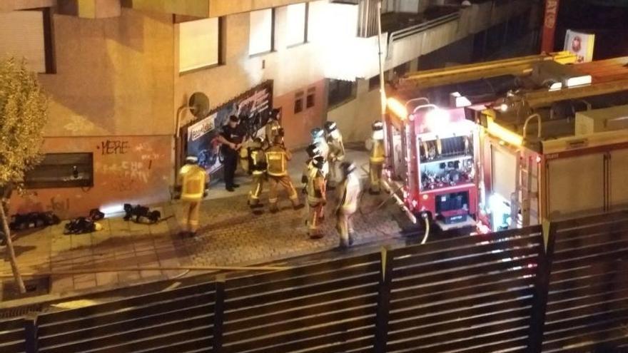 Los bomberos intervienen en el bajo comercial. // FdV