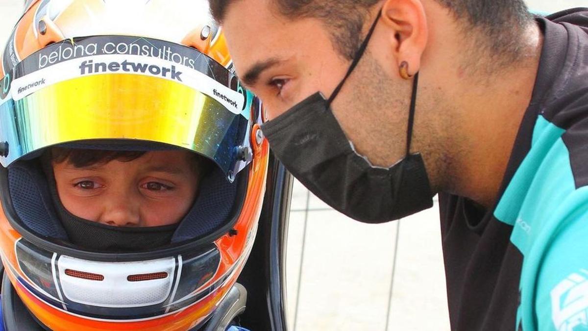 Roc Piñera, sentado en su kart, atiende las explicaciones de su mecánico, Marc Hibern.