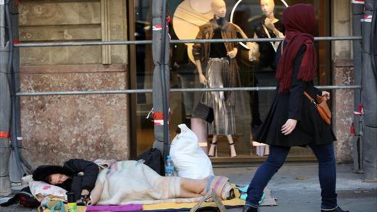 Ola de frío y pobreza 8Un hombre duerme en la calle, en pleno paseo de Gràcia, ayer.