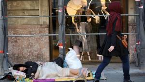 Un hombre duerme en la calle, en el paseo de Gràcia de Barcelona