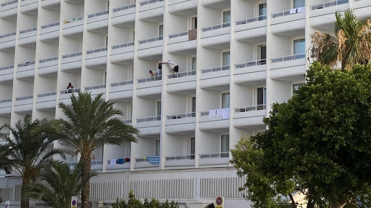 Un turista pasa de un balcón a otro en un hotel de Ibiza
