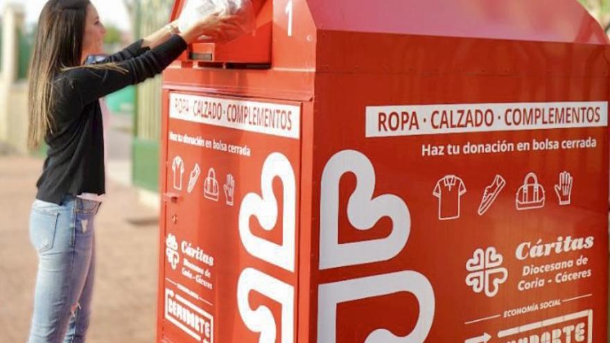 Una mujer deposita ropa en los contenedores rojos de Remudarte.