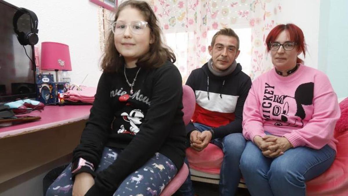 Izaskun, la niña que sufre acoso escolar en el CEIP San Braulio, junto a sus padres en su vivienda de Zaragoza.