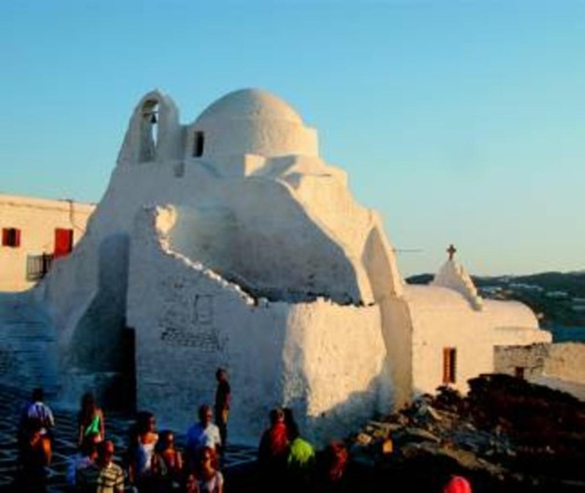 El color predominant als carrers, les placetes i les construccions de Míkonos és el blanc encegador, com es pot observar en aquestes dues fotografies. A la de l’esquerra, un conjunt d’esglésies al costat del port de l’illa. A la dreta, un dels tradicionals carrerons de Míkonos, amb les baranes de les escales pintades de colors. El color predominant als carrers, les placetes i les construccions de Míkonos és el blanc encegador, com es pot observar en aquestes dues fotografies. A la de l’esquerra, un conjunt d’esglésies al costat del port de l’illa. A la dreta, un dels tradicionals carrerons de Míkonos, amb les baranes de les escales pintades de colors.