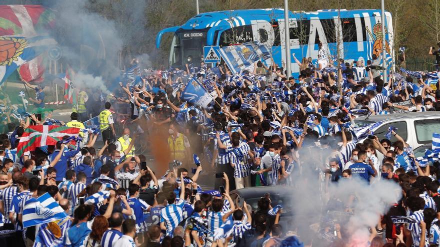 Aficionados de la Real Sociedad despiden al autobús del equipo.