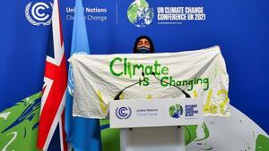 Un activista muestra una pancarta durante la cumbre del clima COP26 de Glasgow