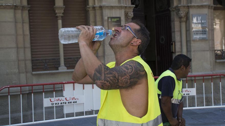 Un treballador, hidratant-se en plena onada de calor a Manresa