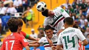 Edson Álvarez cabecea entre varios jugadores de México y Corea del Sur.