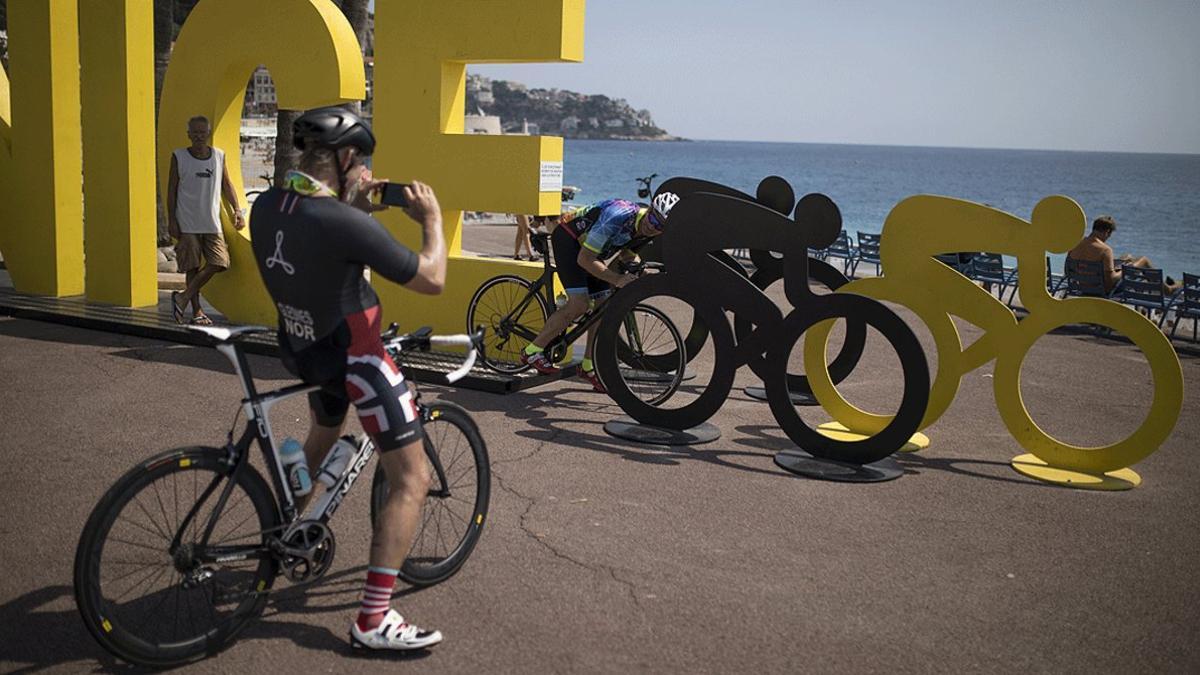 Varios ciclistas se sacan fotos en una instalación colocada en el paseo marítimo de Niza con motivo del inicio del Tour de Francia, este viernes 28 de agosto