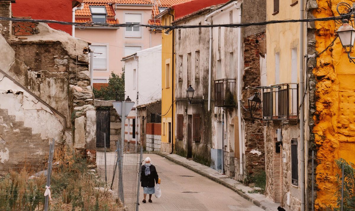 Una mujer lleva la compra por una calle de Cenicientos.