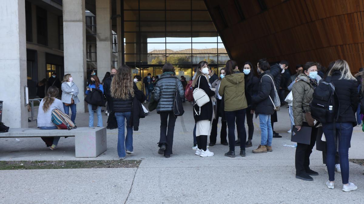 Un grupo de jóvenes esperan para acceder al examen MIR en Zaragoza.
