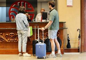 Clientes se registran a su llegada a la recepción de un hotel.