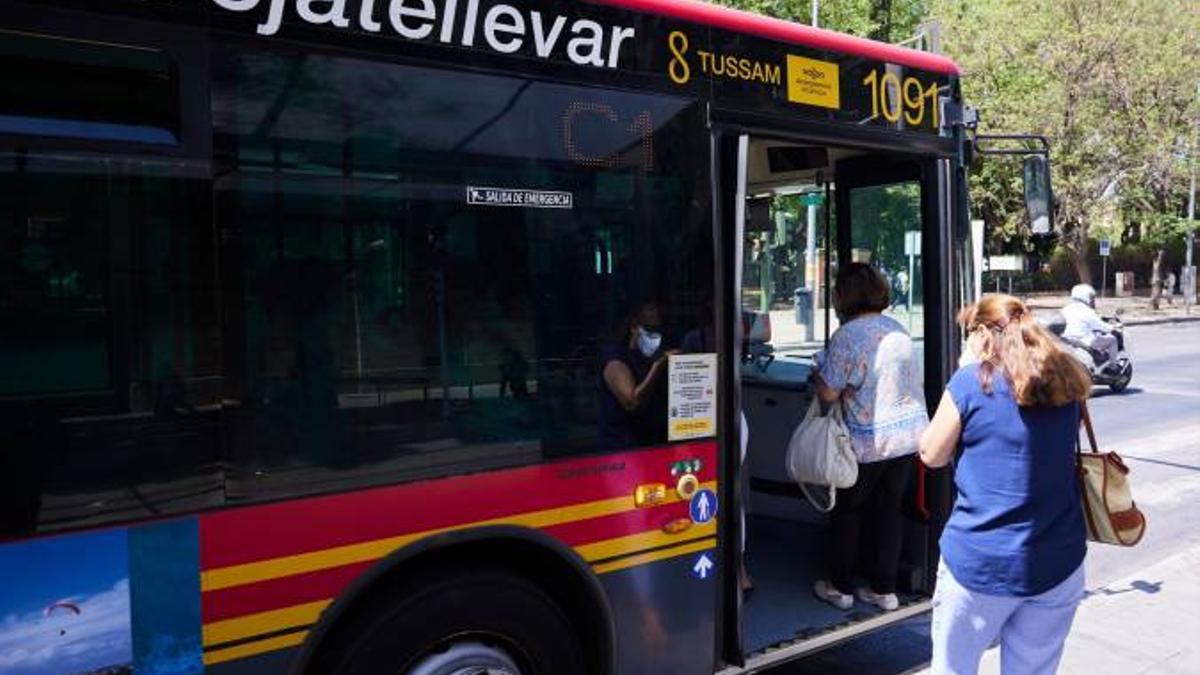 Dos mujeres esperan para subir a un autobús urbano de TUSSAM en Sevilla.