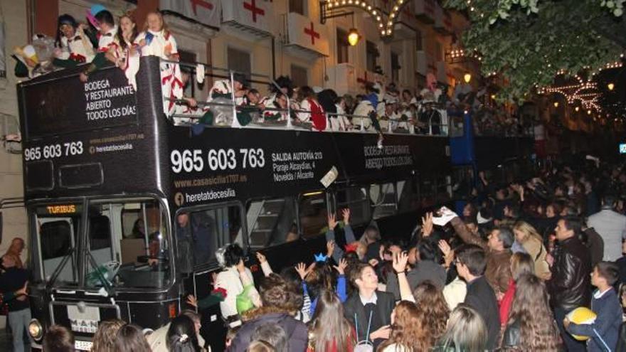 Un gran autobús de dos plantas repleto de festeros que lanzaron obsequios a su paso por San Nicolás en medio de una multitud de espectadores.