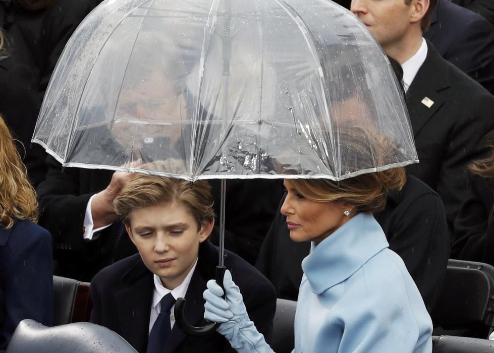 Melania and Barron Trump shield under an ...