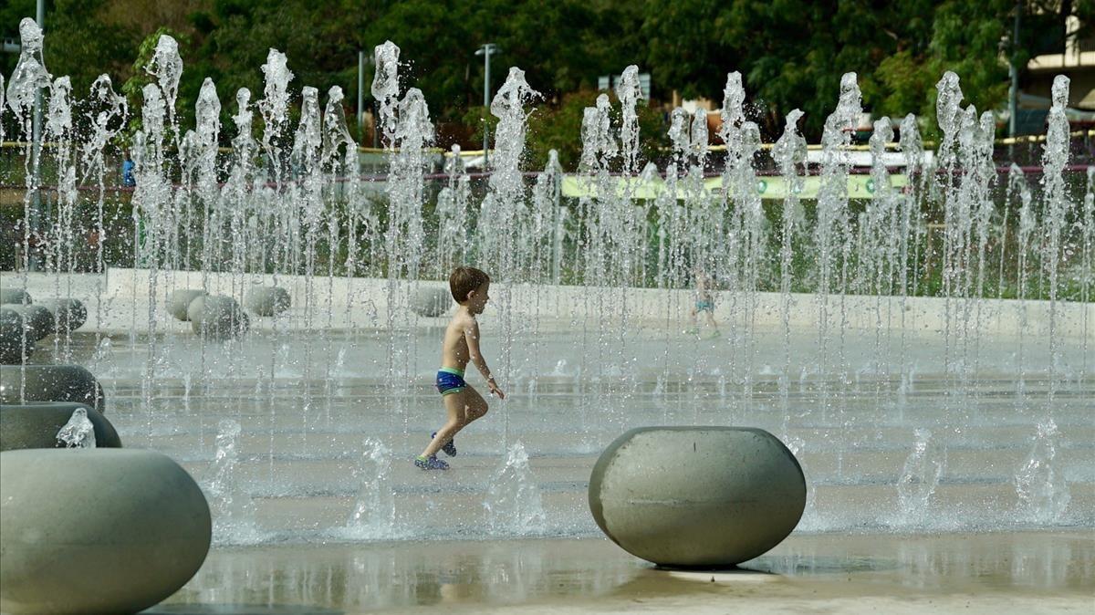 Un niño se refresca en las fuentes del parque de Santiburcio.