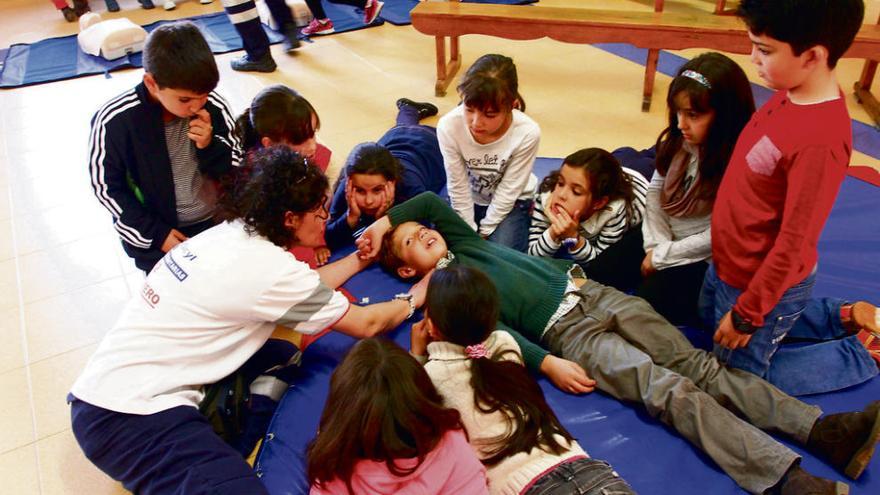 Los alumnos atienden a las explicaciones de la médico sobre primeros auxilios.