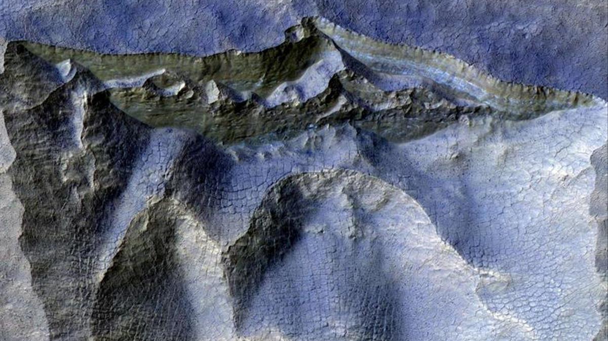 Acantilados de hielo antiguo en la superficie de Marte, con paredes de acantilados polvorientos de color marrón y hielo azul claro