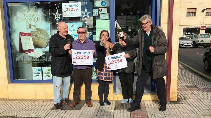 Javier Alonso, Maximino Carbajosa, Anna Fernández, Adela Álvarez y Santiago Morales, ayer, abriendo una botella de sidra en la puerta de la administración de loterías de Grado.