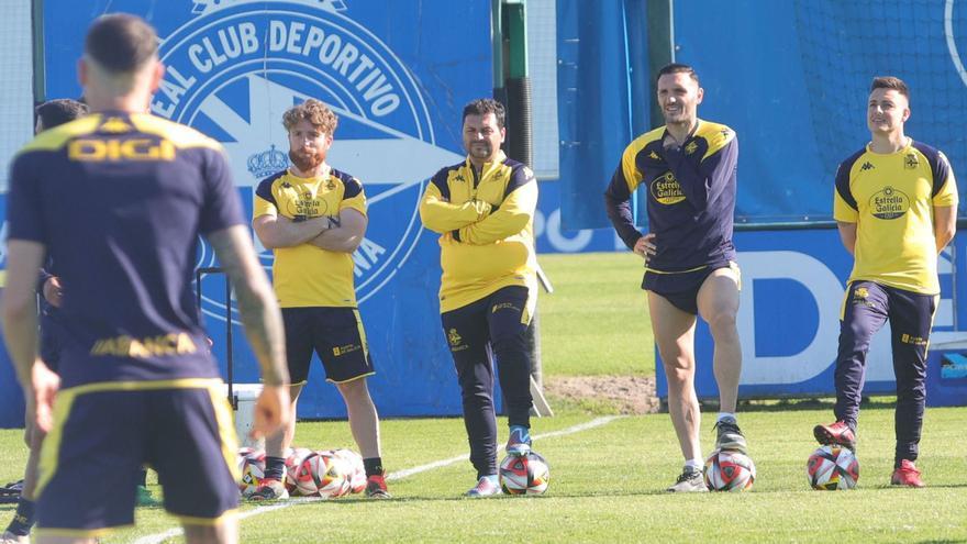 Lucas observa el entrenamiento de ayer en Abegondo rodeado de miembros del cuerpo técnico. |  // IAGO LÓPEZ