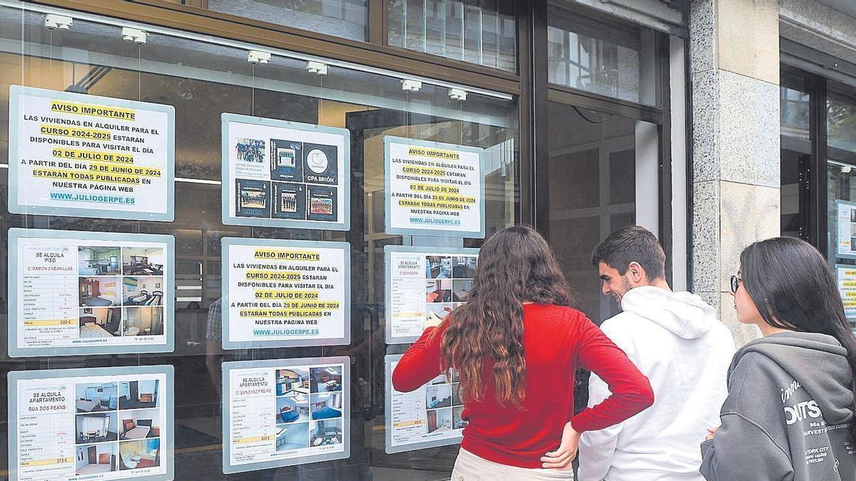 Uno estudiantes miran las ofertas de pisos en una inmobiliaria