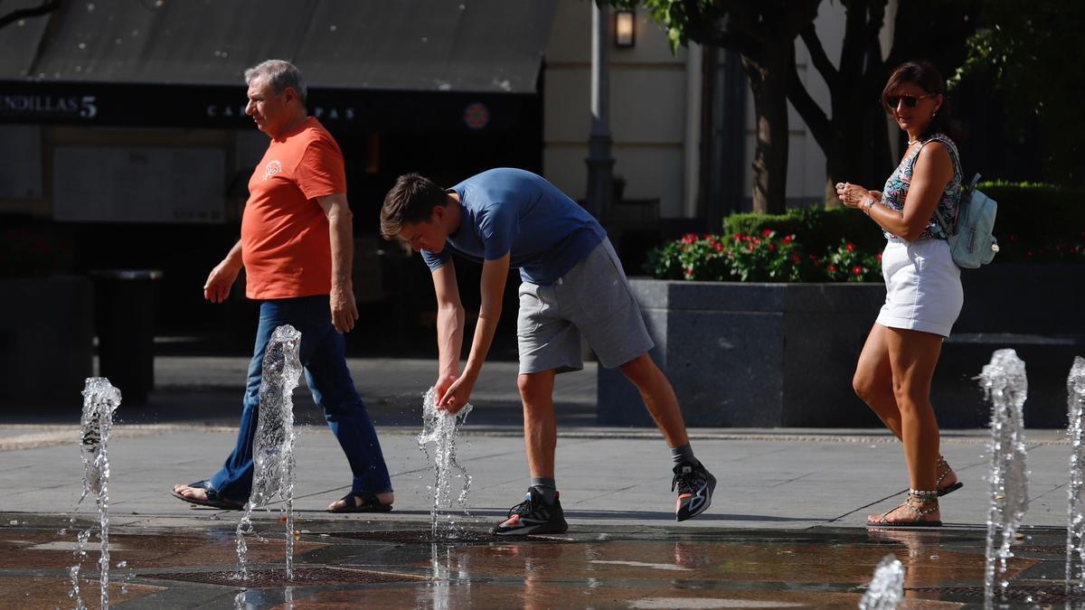 Viandantes se refrescan en las fuentes de Las Tendillas