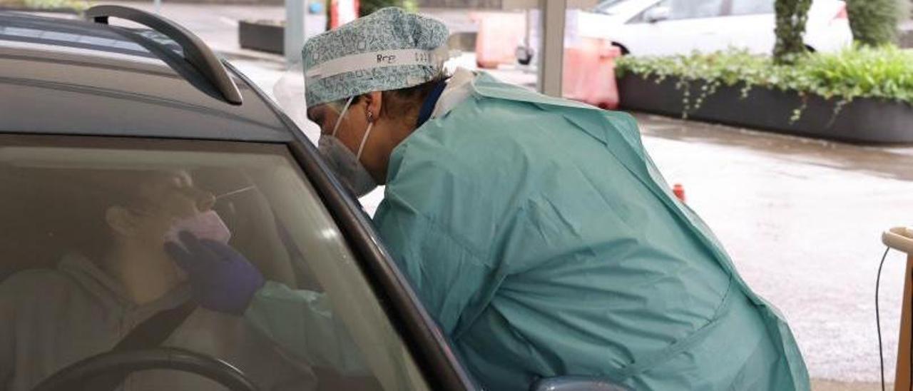 Una sanitaria realizando una PCR a una paciente en el Covid auto del Hospital Álvaro Cunqueiro.