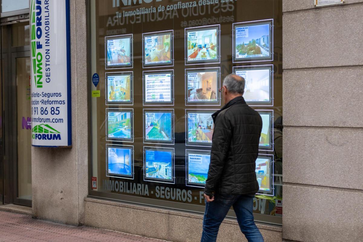 Un hombre mira inmuebles a la venta en el escaparate de una inmobiliaria
