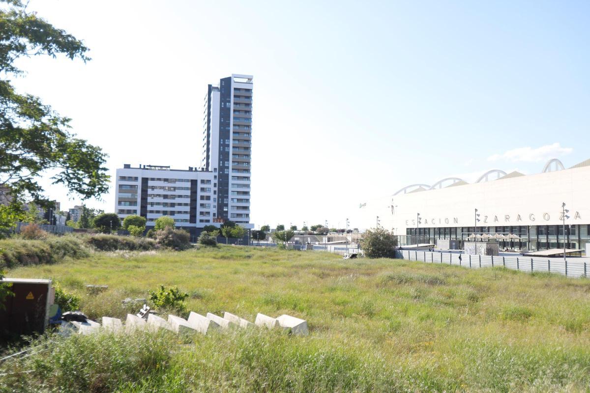 Parcela en venta de ZAV; a la derecha, la estación Delicias, y al fondo, un edificio recién construido.
